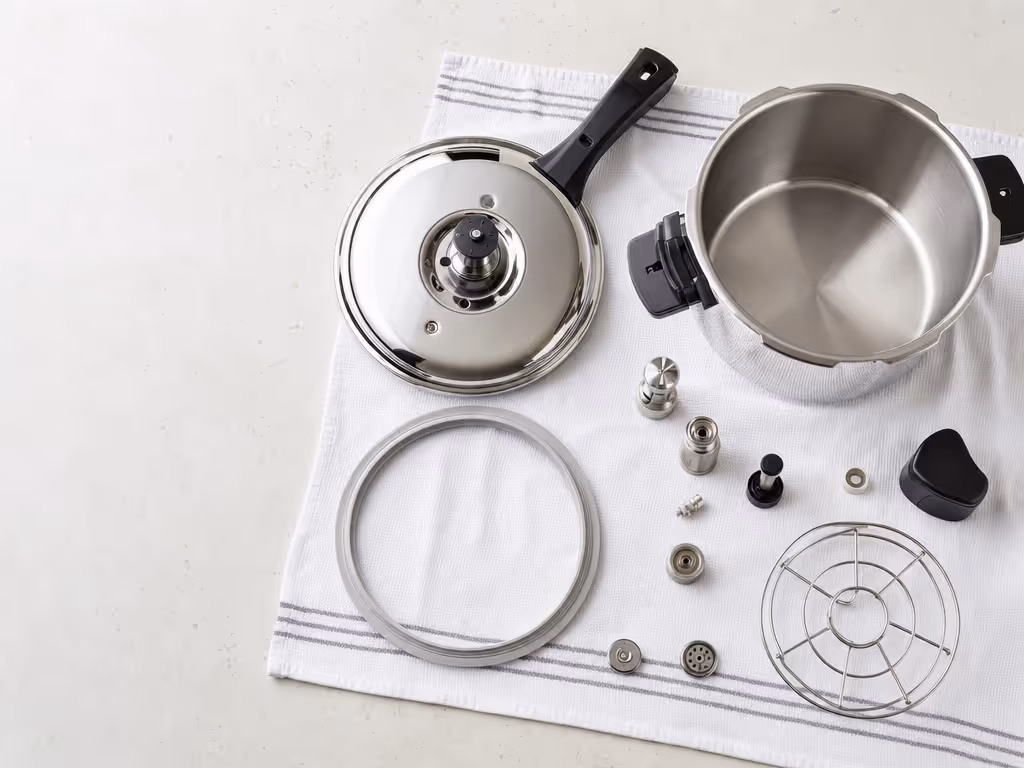 pressure_cooker_lid_valve_and_removable_components_on_kitchen_towel